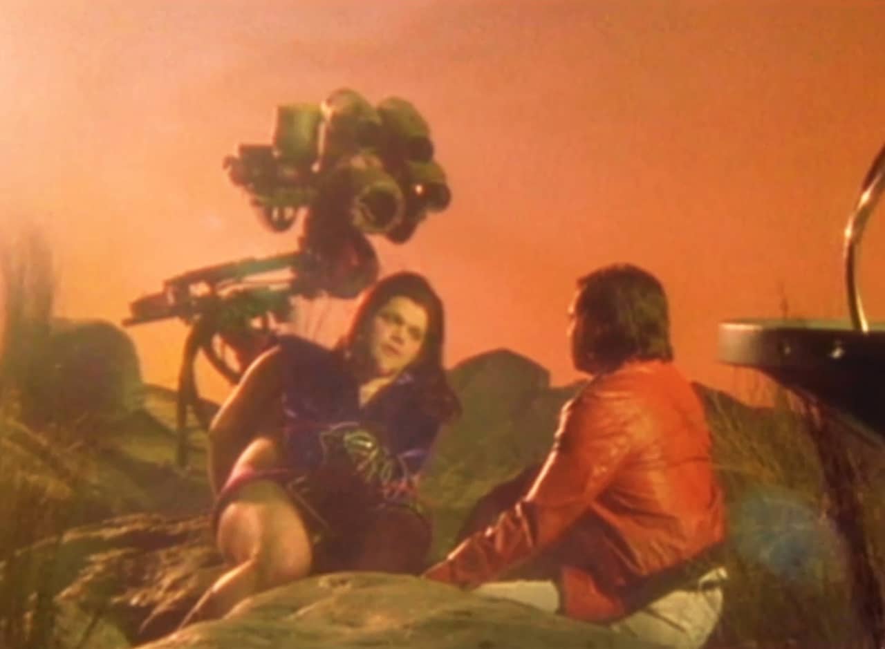 Glynn Nimron, leaning in the grass, next to Jack; the sky is an orange red