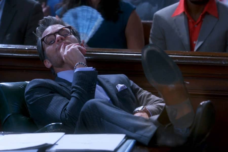 Rake Grinder leaning back in his chair, feet on the table