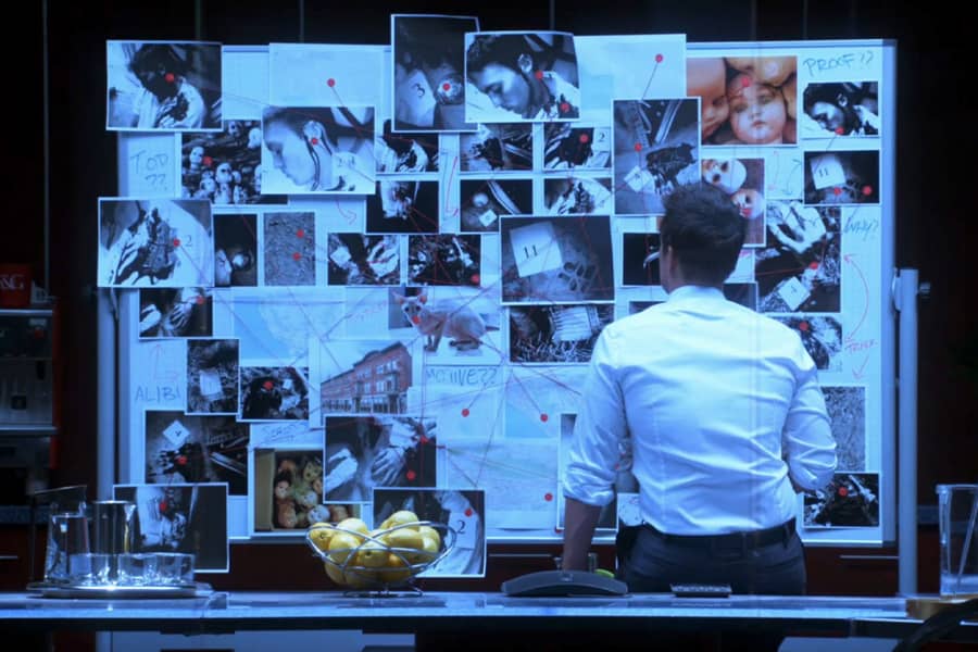 Grinder in front of a large evidence board