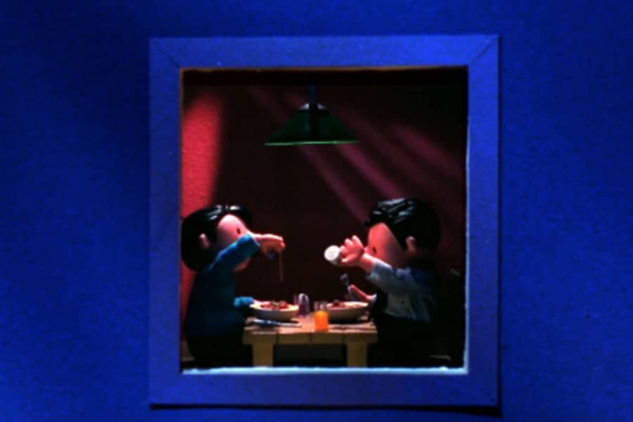 two men having dinner through a window