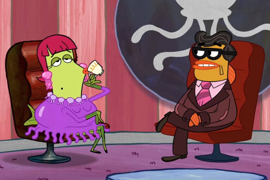 Jeff Jellyson talking to a guest sipping tea and wearing a jellyfish dress