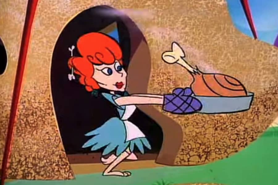 red-haired woman holding a big turkey leg in a pan, running out of a stone house