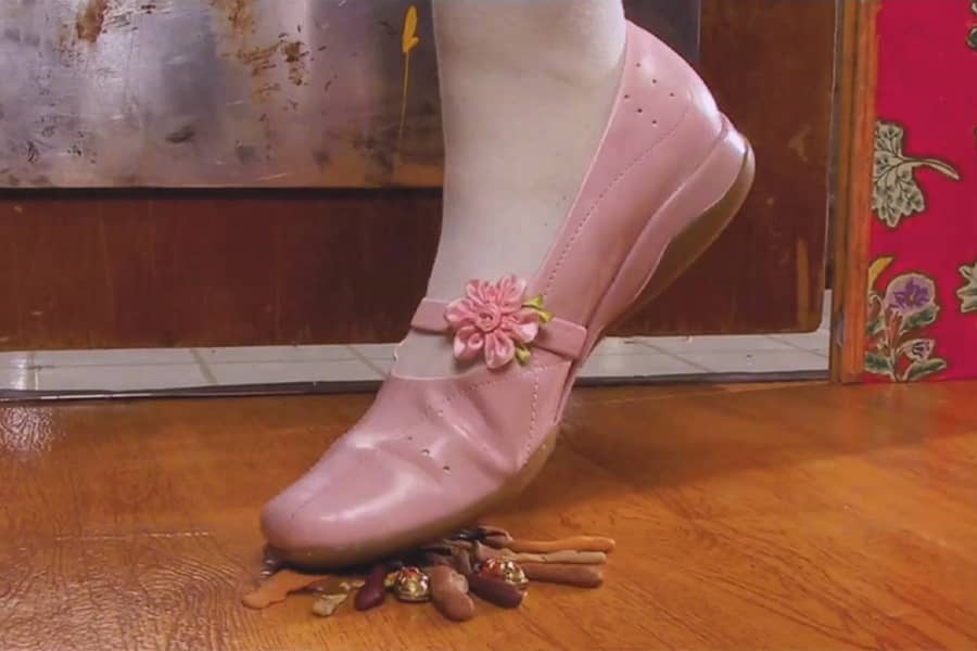 a pink shoe steps on little roach and squishes him