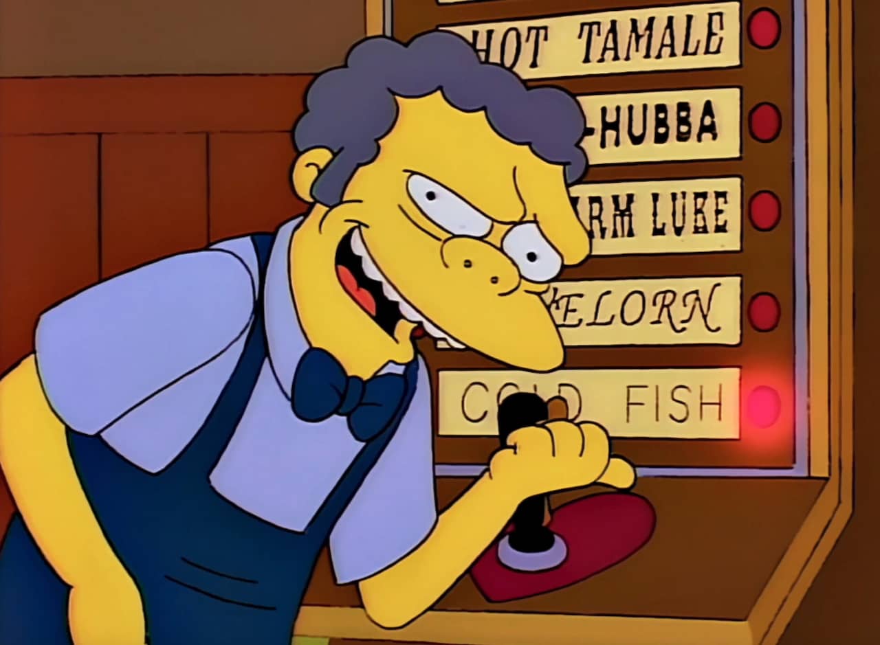 Moe pointing and smiling at a light-up love testing machine