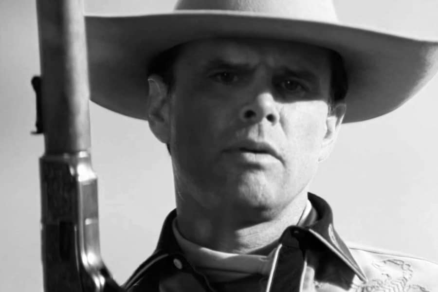 Howard holding his gun toward the sky