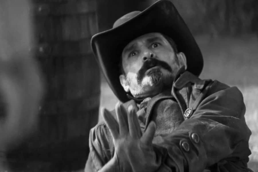 cowboy with a mustache on the ground pleading for mercy