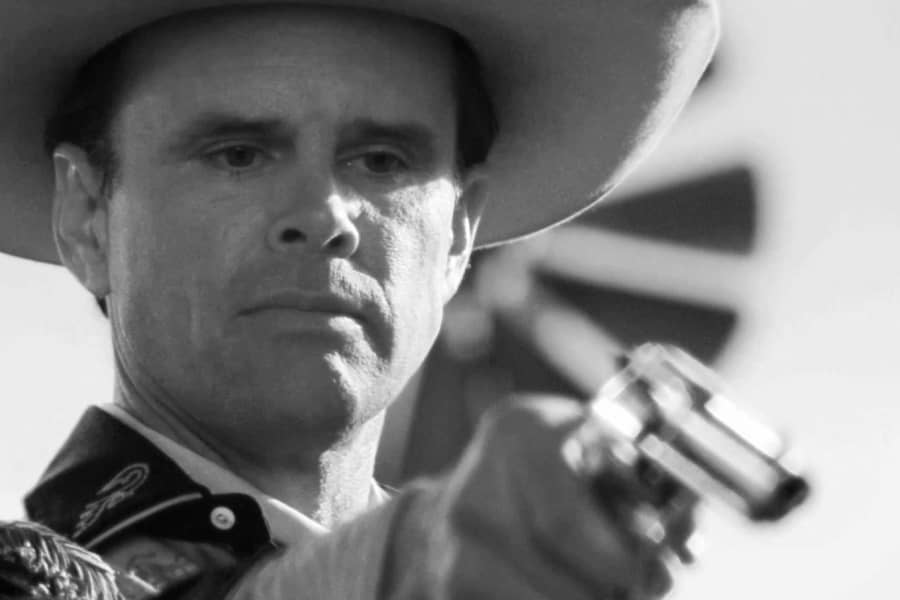 Howard pointing a handgun