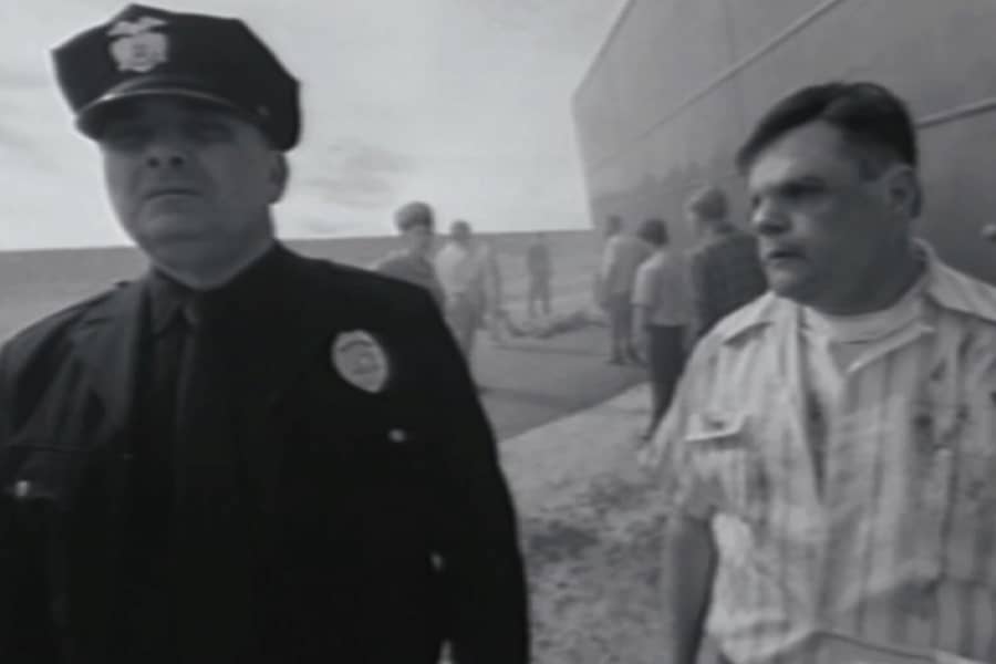 man talks to a police officer at the scene of an accident