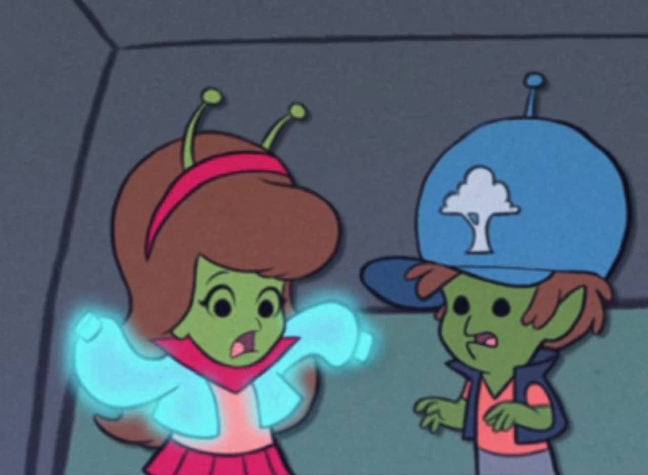 two alien kids, the girl (Mavis) has a glowing sweater