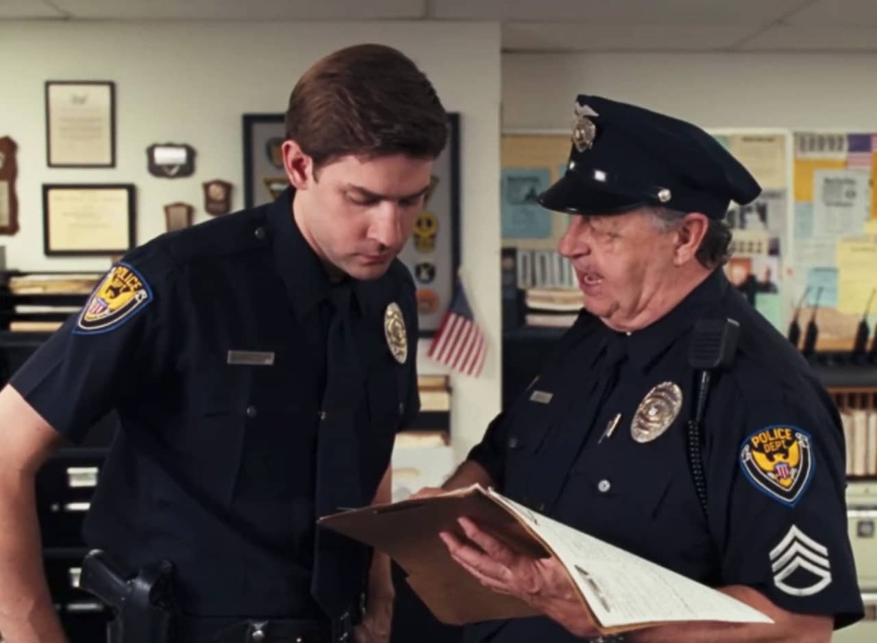 John Krasinski as Maricich and Paul Dooley as Devol, cops looking over paperwork