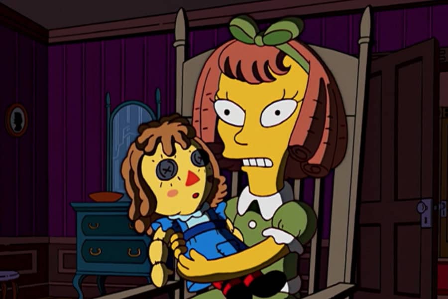 the girl holds a rag doll with button eyes