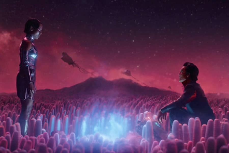 the Captain and Nav Bot 337 Alt 66 sit by a blue fire on a purple planet