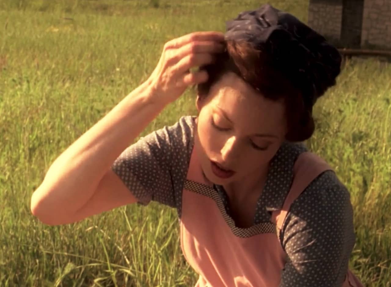 Valerie Page works in a field and adjusts her hair