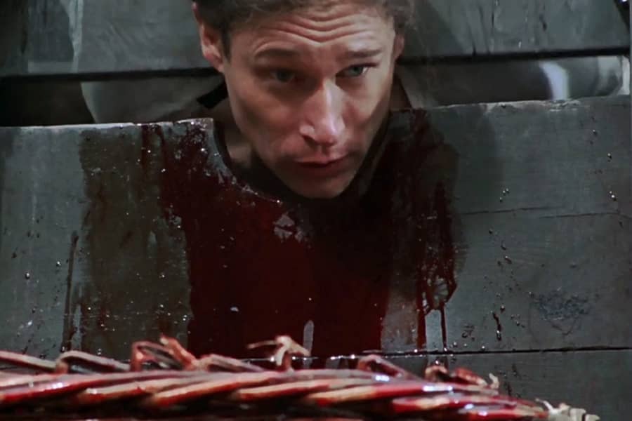 man being put in a bloody guillotine