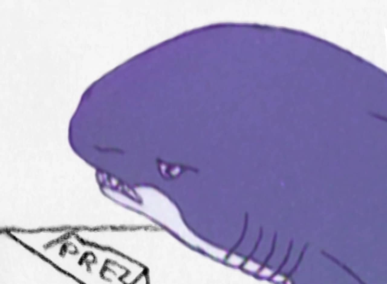 Shark at a desk with a nameplate that says “Prez”