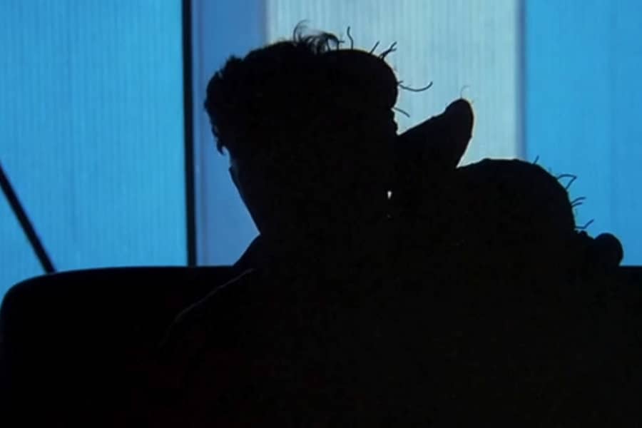 a guest hidden in silhouette, it looks like they have a large growth on their back/head