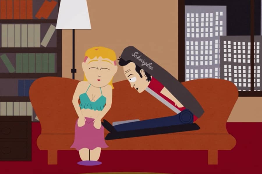 stapler Rob leaning in to kiss a woman on a couch
