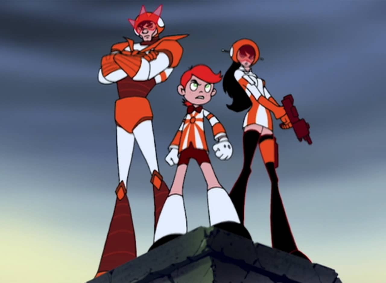 The Sun Riders in their orange and white costumes atop a clif