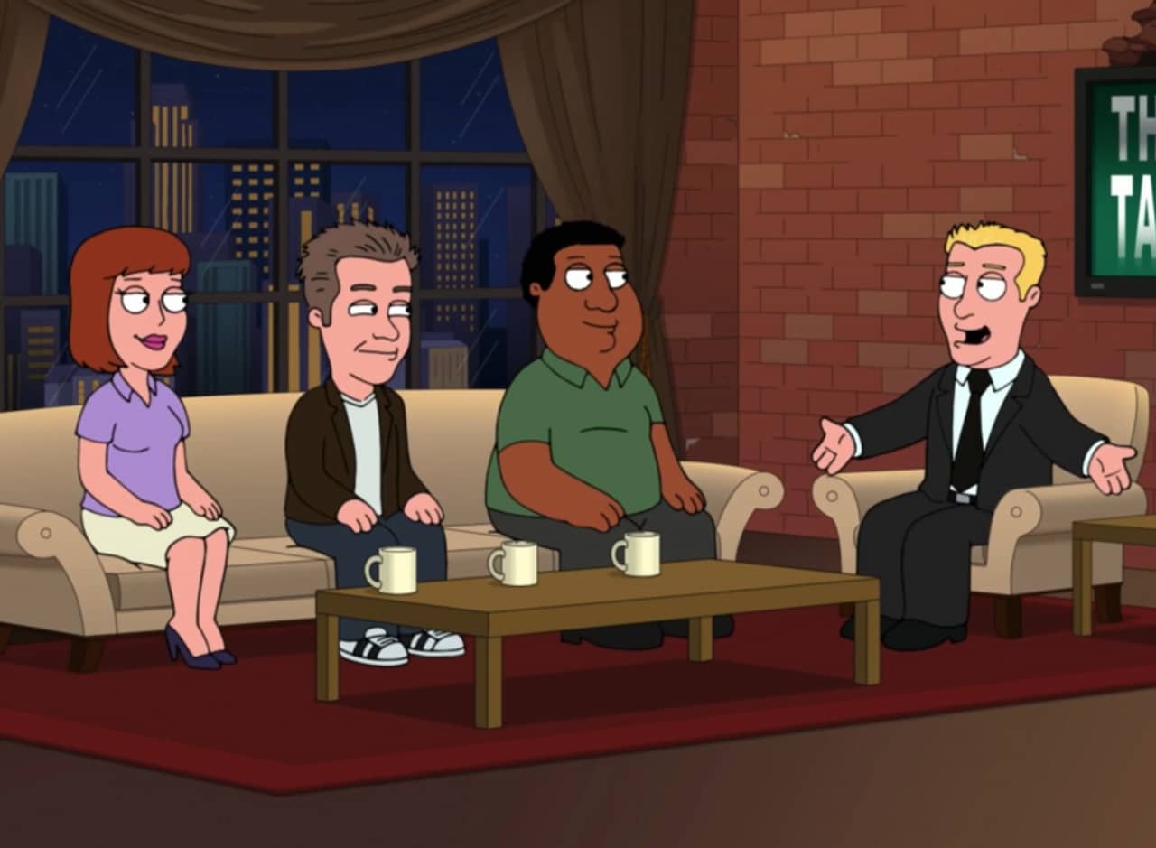 four people sitting on a set talking