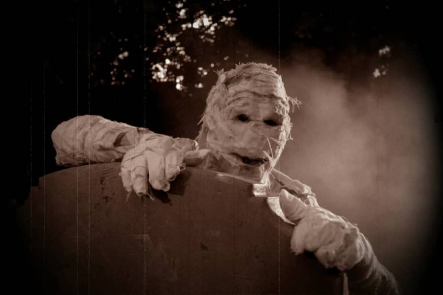 mummy lifting itself up on a gravestone