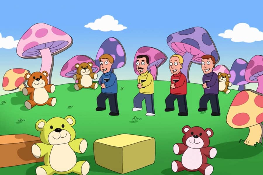 four men in colorful turtlenecks walk along the grass in a giant mushroom fantasy land