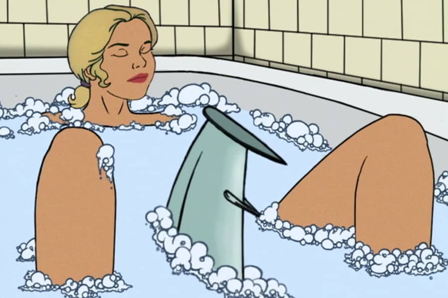 a robot shark fin emerges between the legs of a woman in a bubble bath