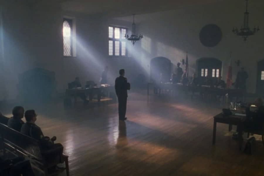 Lieutenant Stevens stands alone in a large room in front of a military panel