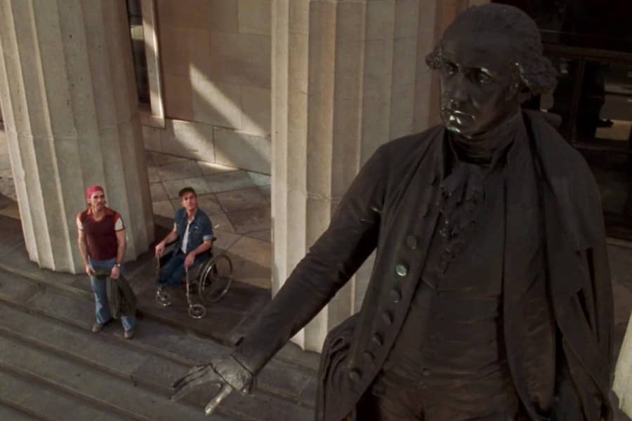 Danny and Billy in street clothes looking up at a statue of George Washington