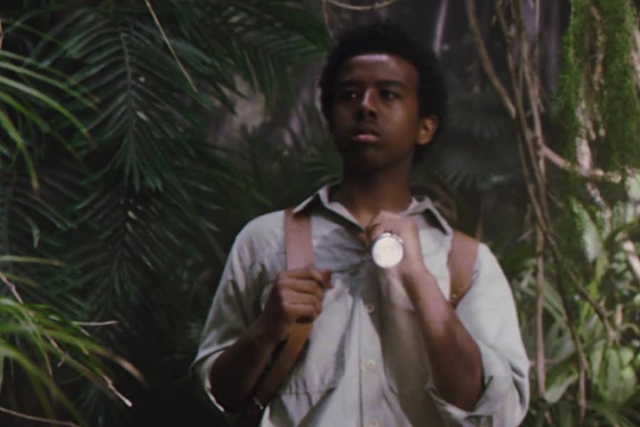 Rosser, Grant’s young helper, holds up a flashlight in the jungle
