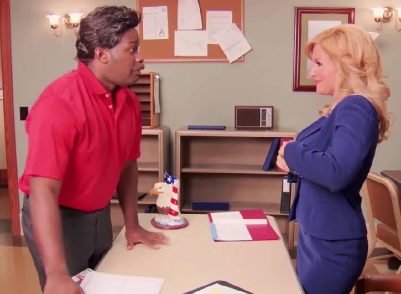 Brandi Maxxxx as Leslie Knope faces off with Dong Swanson (wearing his signature red polo and black pants)