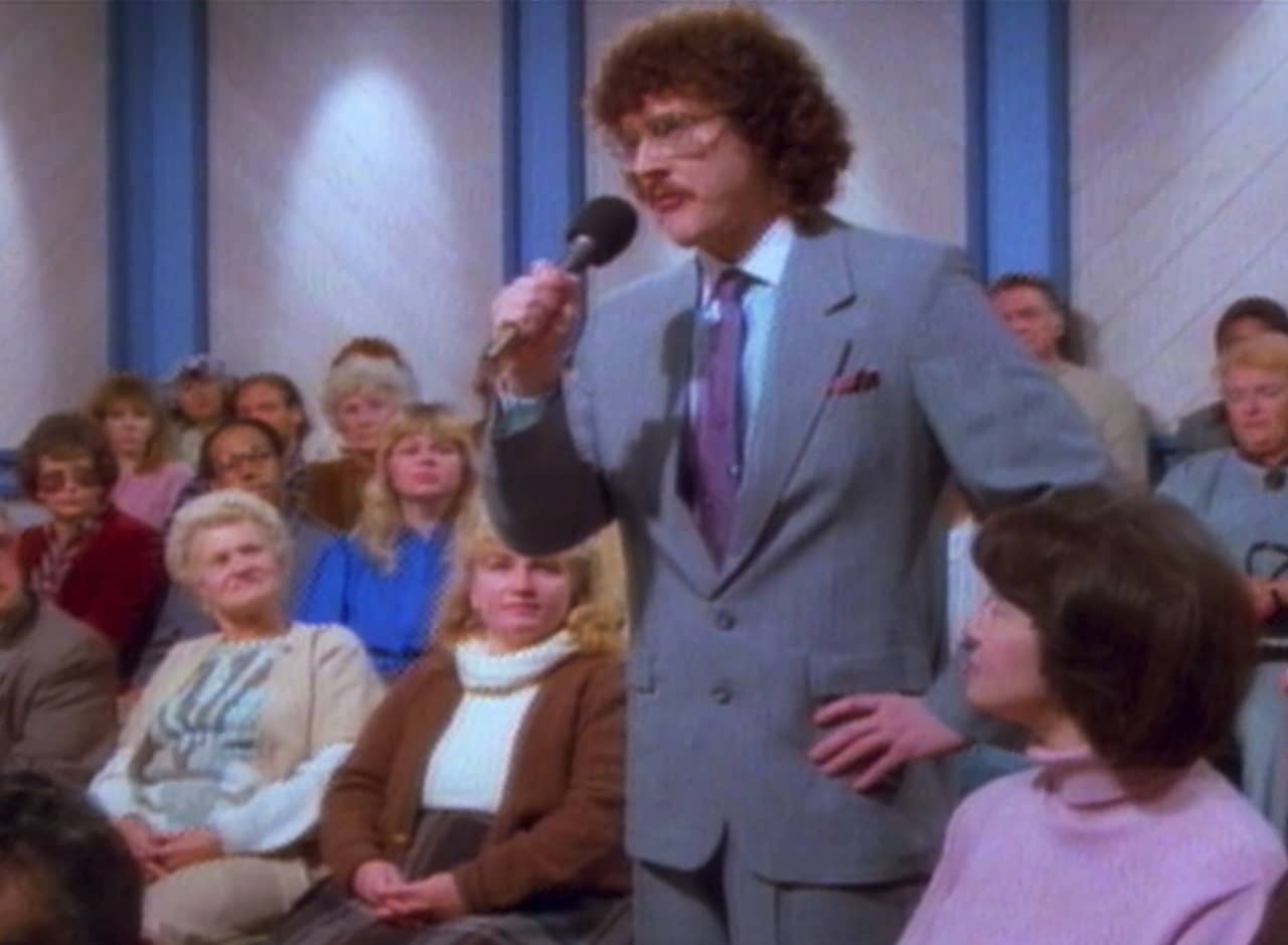 George Newman speaking into a microphone from the audience