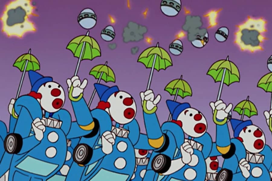clown robots with tiny umbrellas are showered with exploding eggs