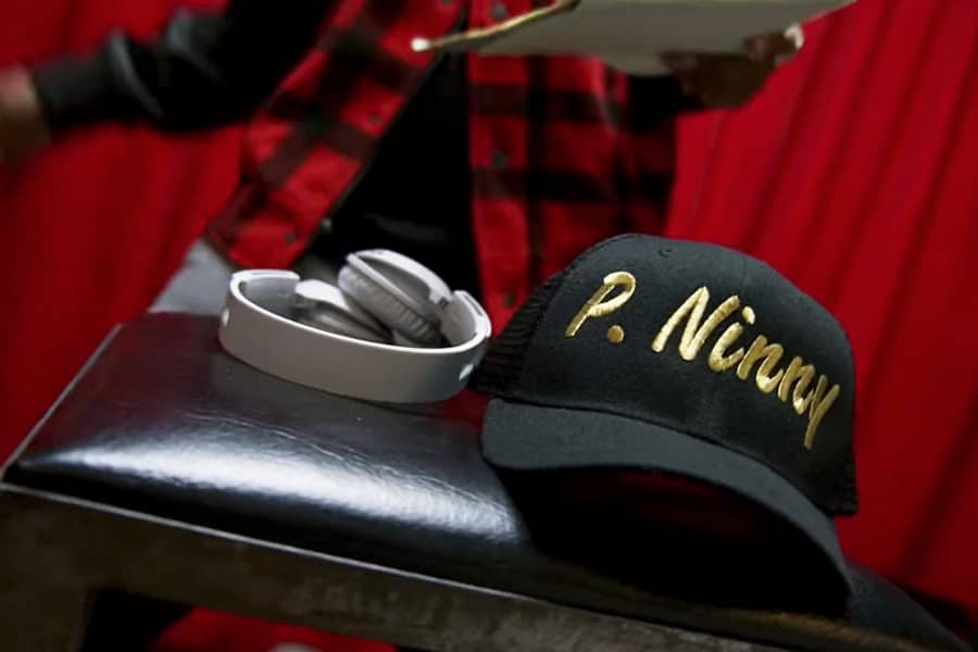 a closeup of headphones and a hat embroidered P. Ninny