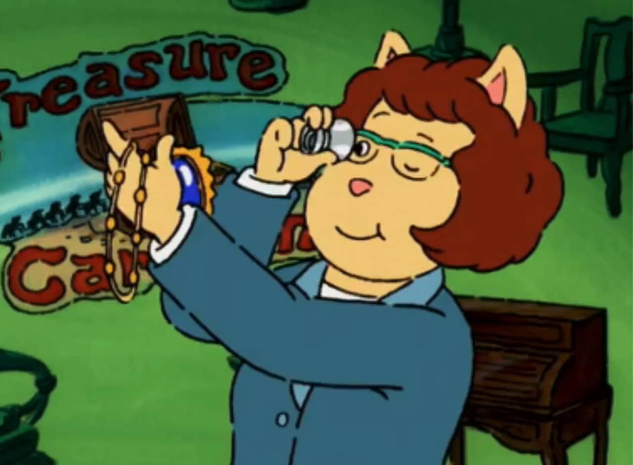 host of Treasure Caravan inspecting a necklace with a magnifying glass