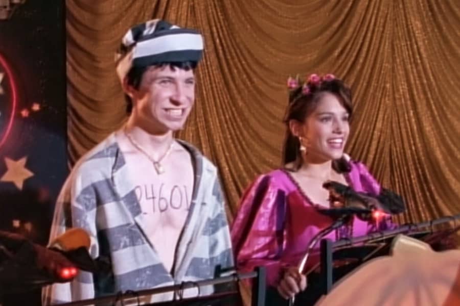 two teen contestants in Hallowen costumes, a boy in prisoner costume, and a girl in a princess costume
