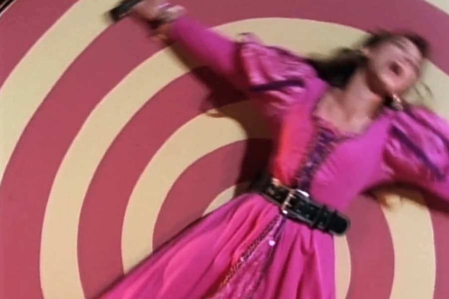 girl screaming, strapped to a wheel and spinning around