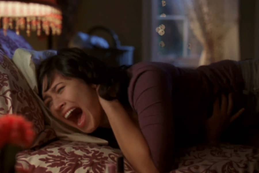 Rochelle in bed screaming as she clutches her neck