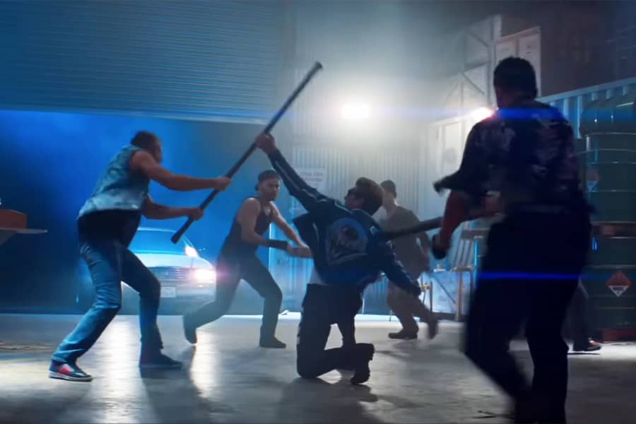 Johnny Cage fighting a bunch of guys in a warehouse