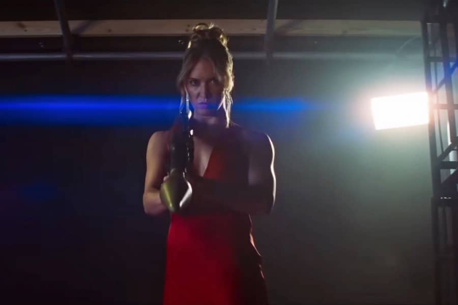 a woman in a red dress aims a bazooka