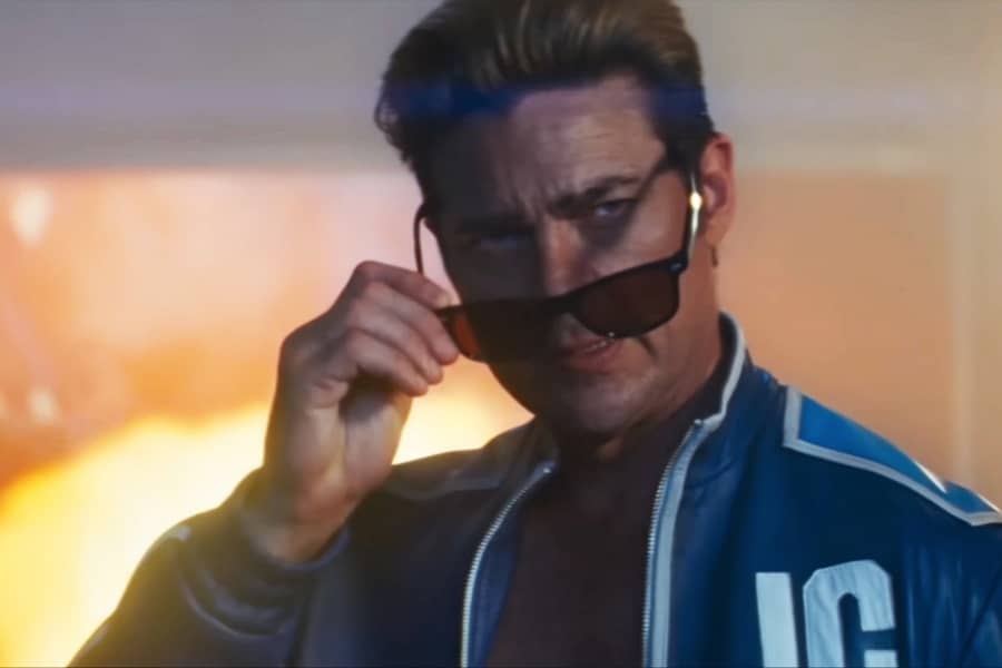 Johnny taking his shades off with an explosion behind him