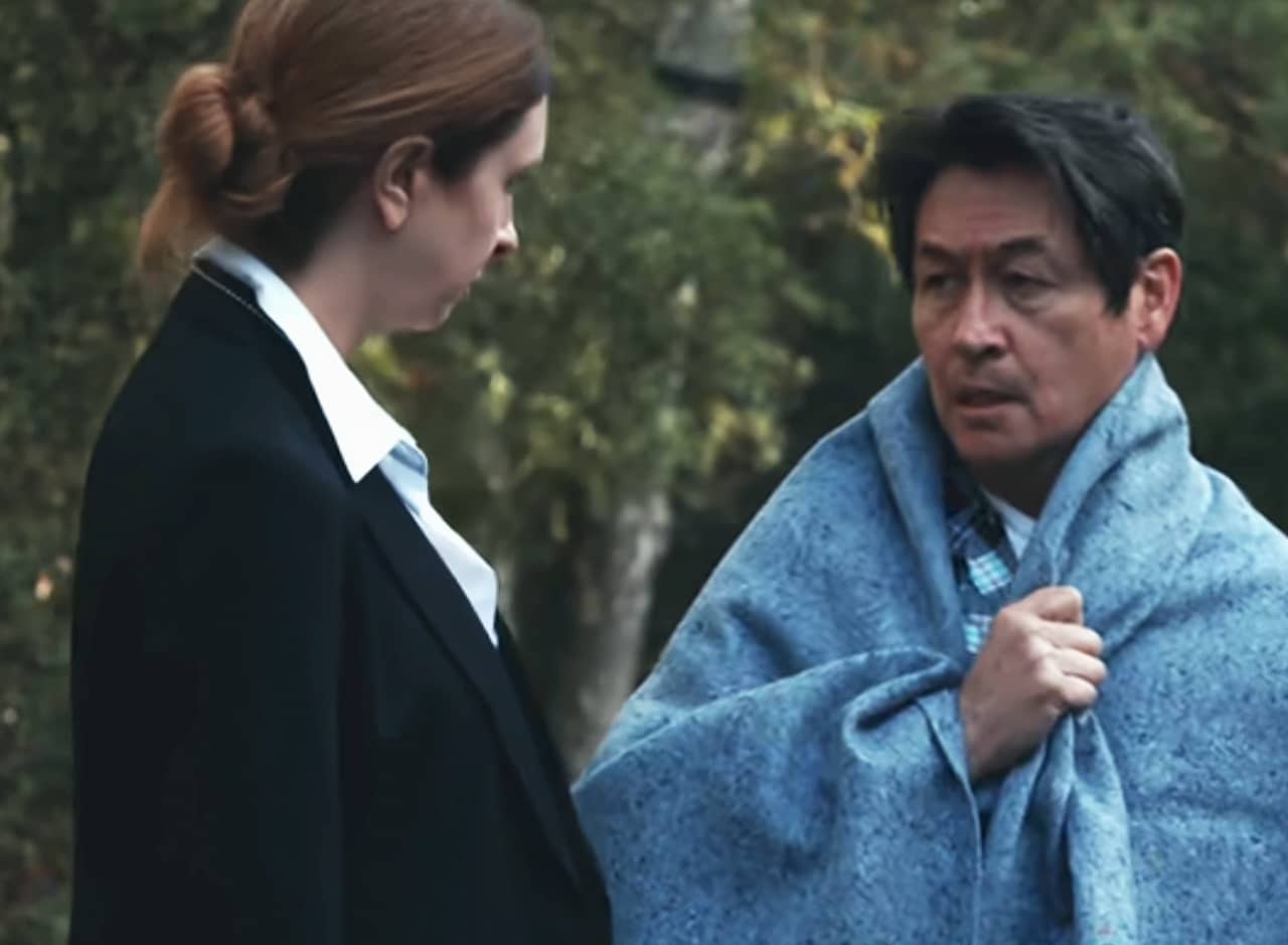 Reenactment of David Kim wearing a blue blanket and speaking to Detective Vick