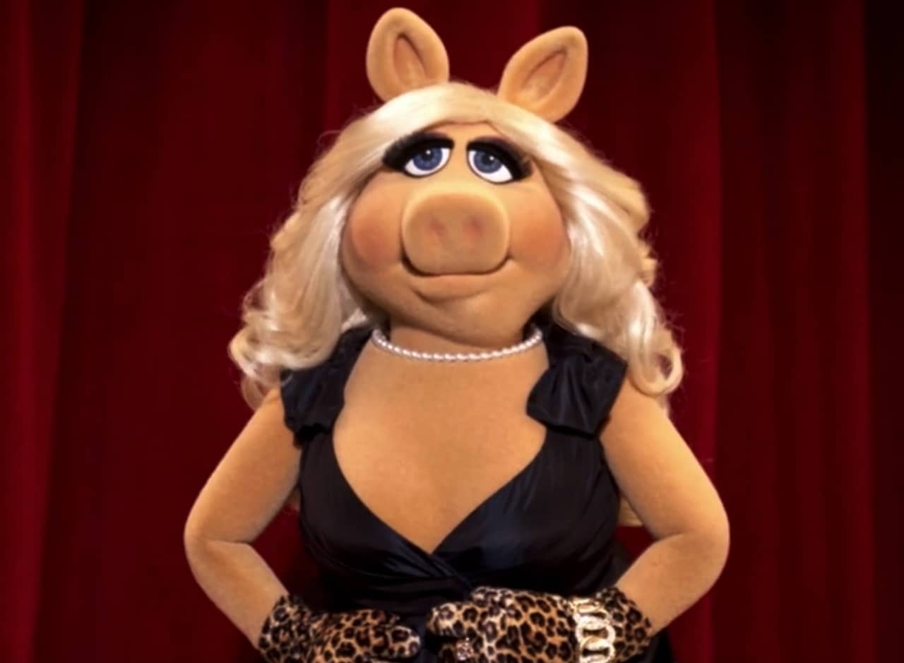 Miss Piggy in front of a red curtain