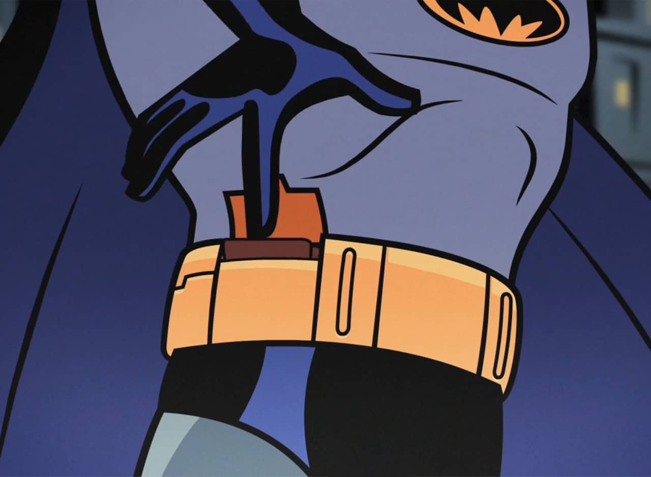 Batman putting a wallet into a little compartment on his utility belt