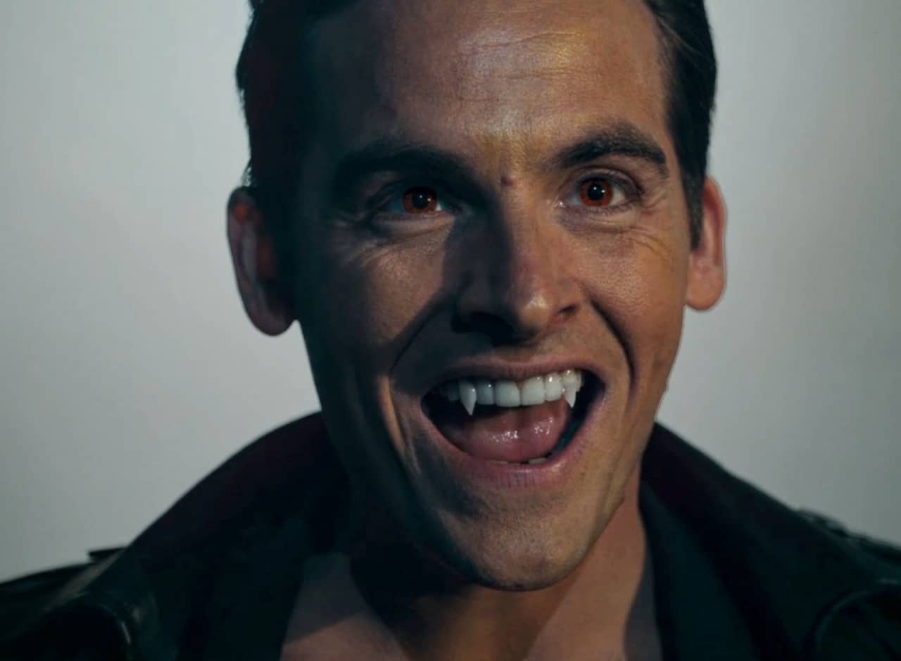 Stoker Ramsey with red eyes and exposed vampire teeth