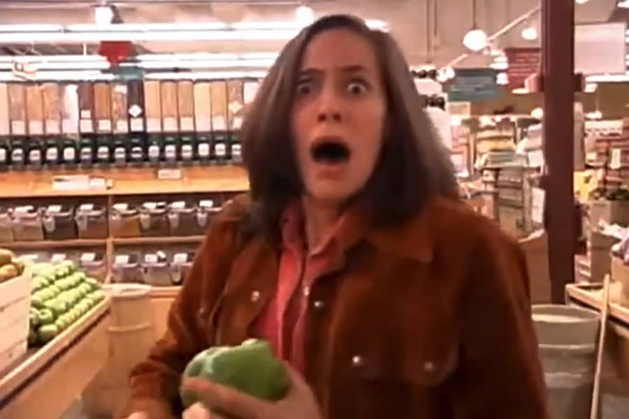 woman holding a green pepper and screaming
