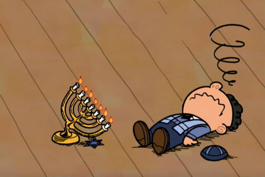 menorah tilted over and a boy laying on the ground in frustration, his yarmulke on the floor next to him
