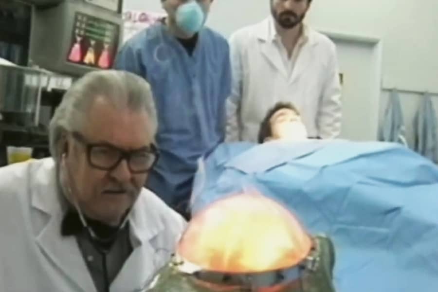 a doctor kneels in front of Walter the Frog whose brain is glowing red