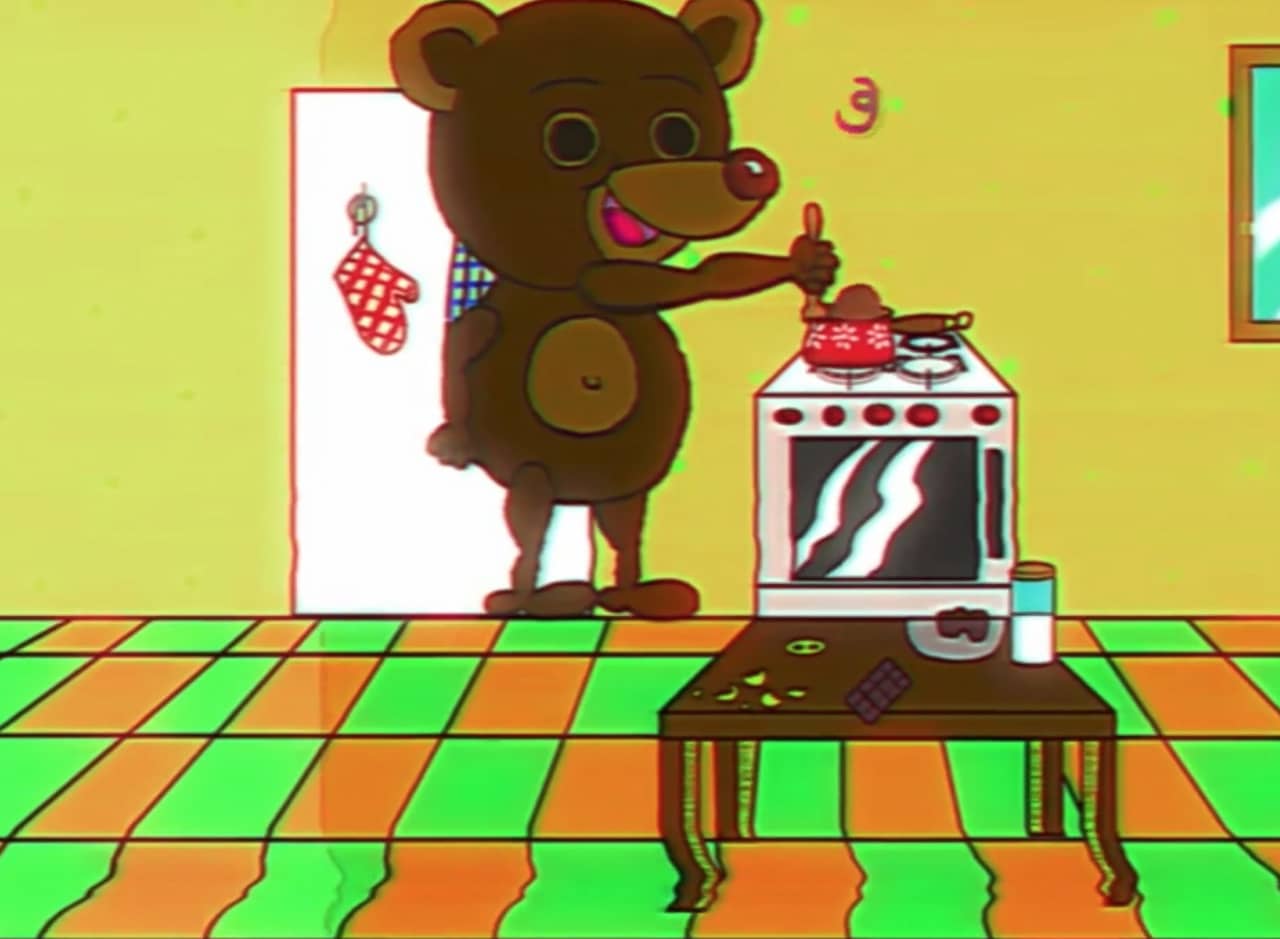 Little Teddy stirring food on the stove