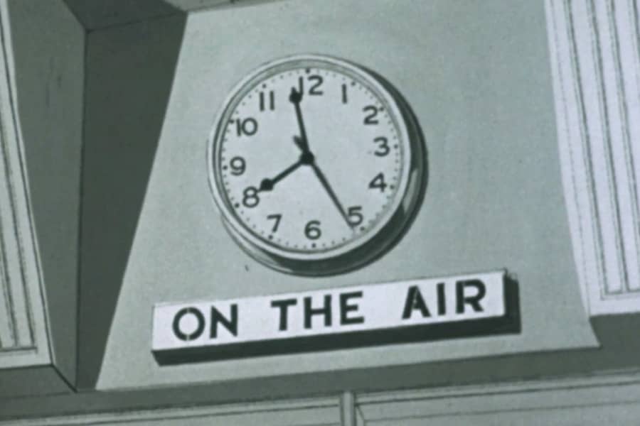 a clock with a sign below “On the air”