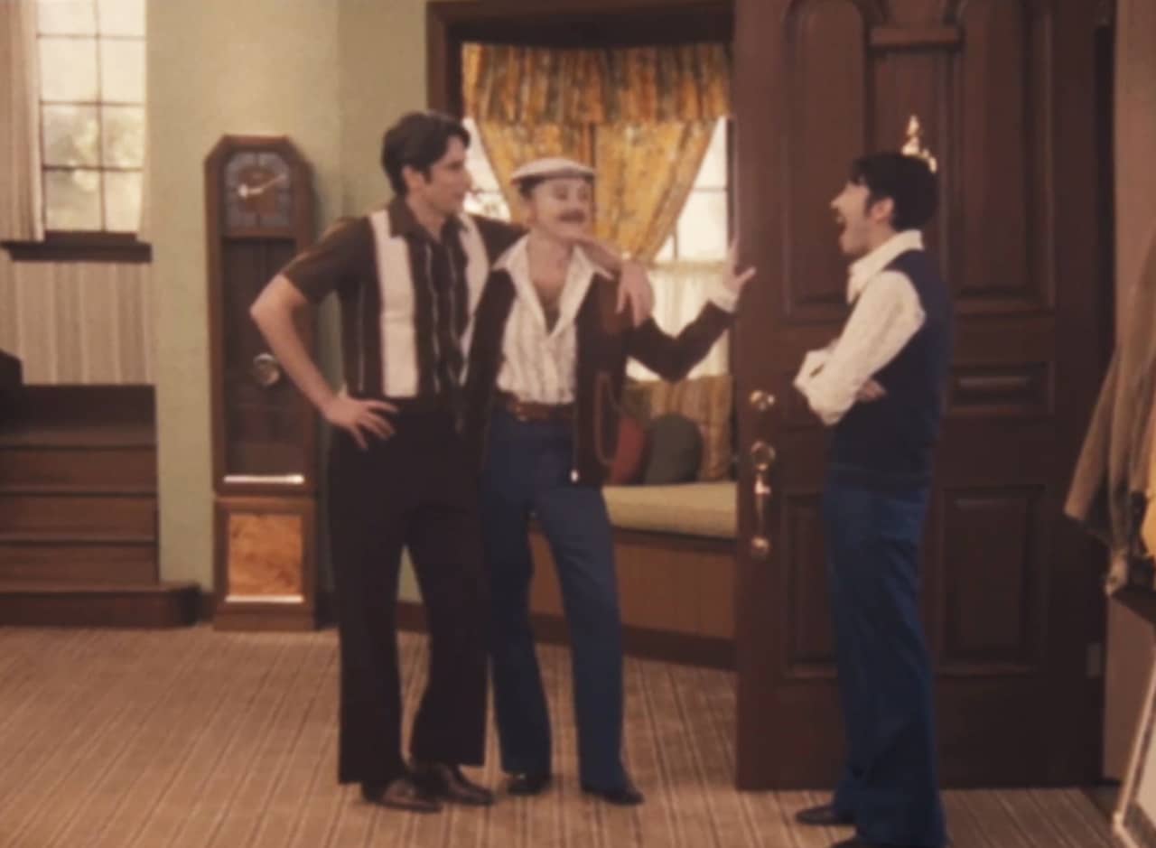 Deborah, dressed like a man, with Frank at the door with Gino